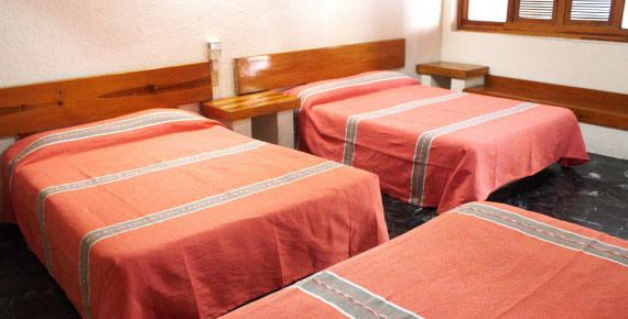 Habitación triple del Hotel Avenida Ixmiquilpan con cama full-size, decoración rústica y amenidades modernas en Hidalgo